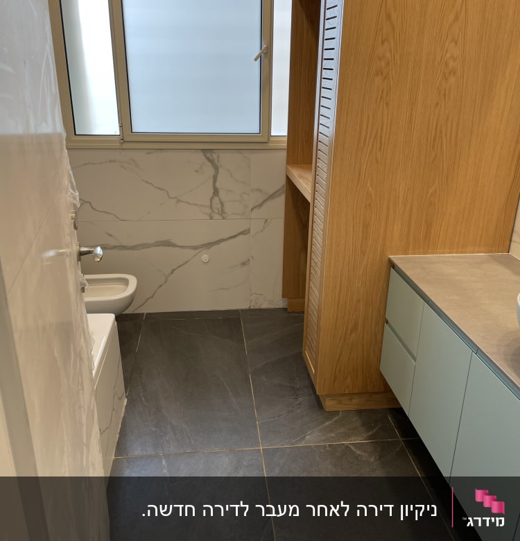 חדר אמבטיה עם רצפה נקייה וארון עץ